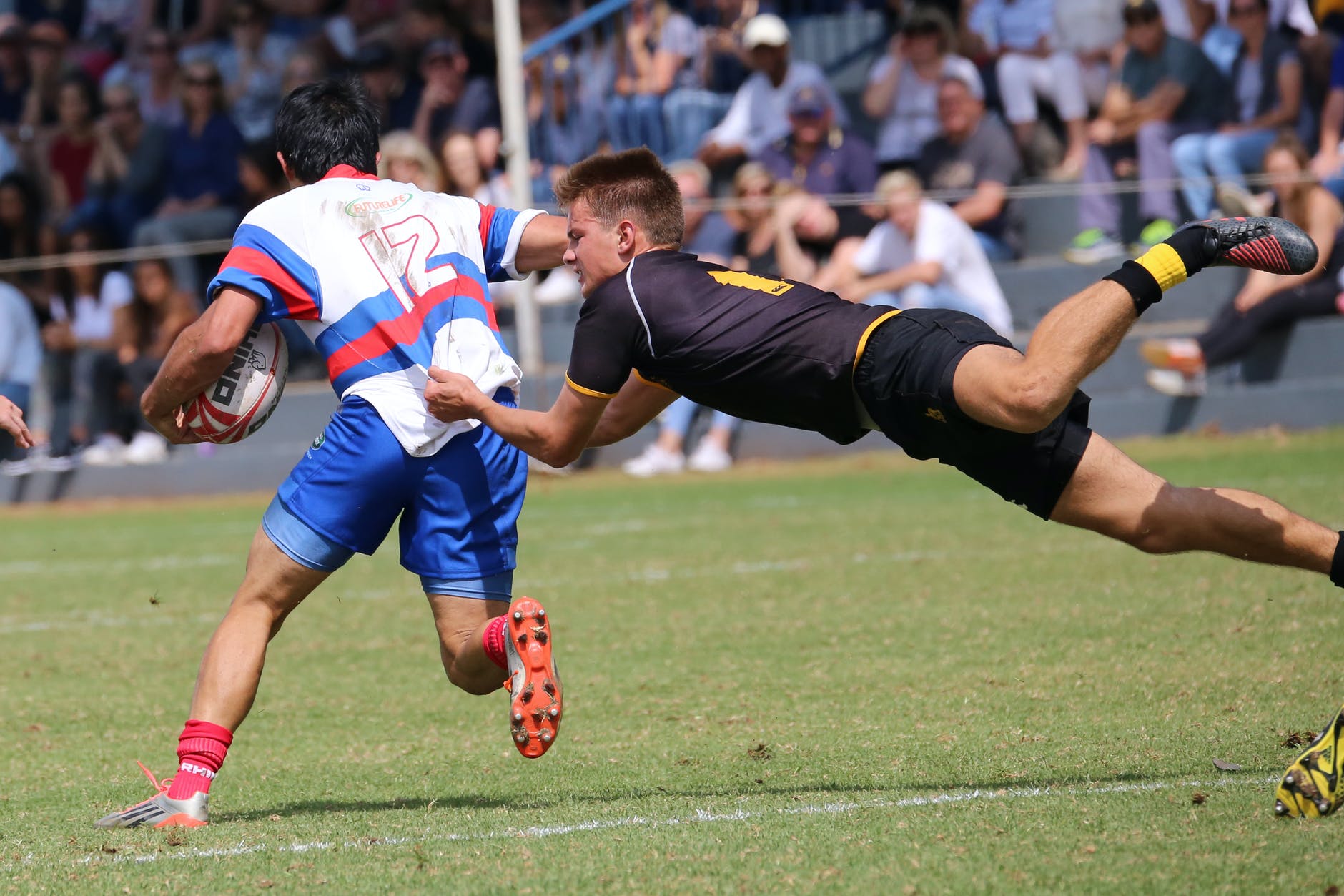 man in black and yellow jersey shirt playing rugby