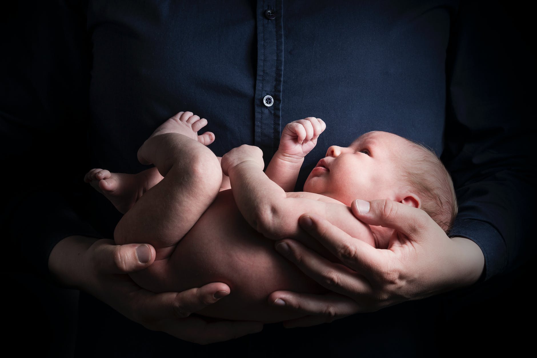 close up photo of a person carrying a baby