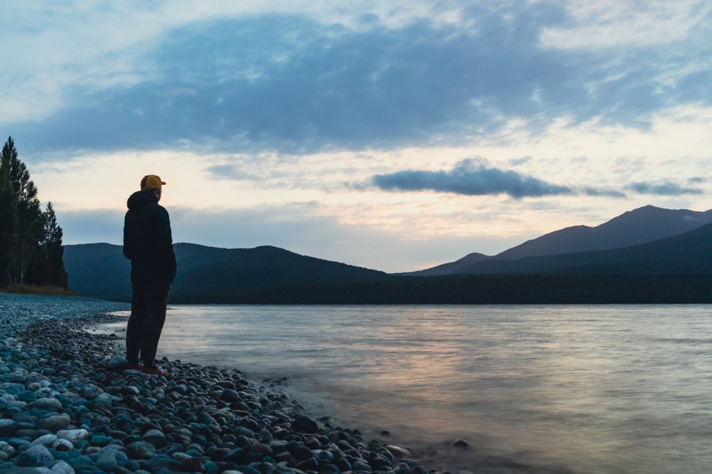 man standing at lake te anau with long shutter speed 