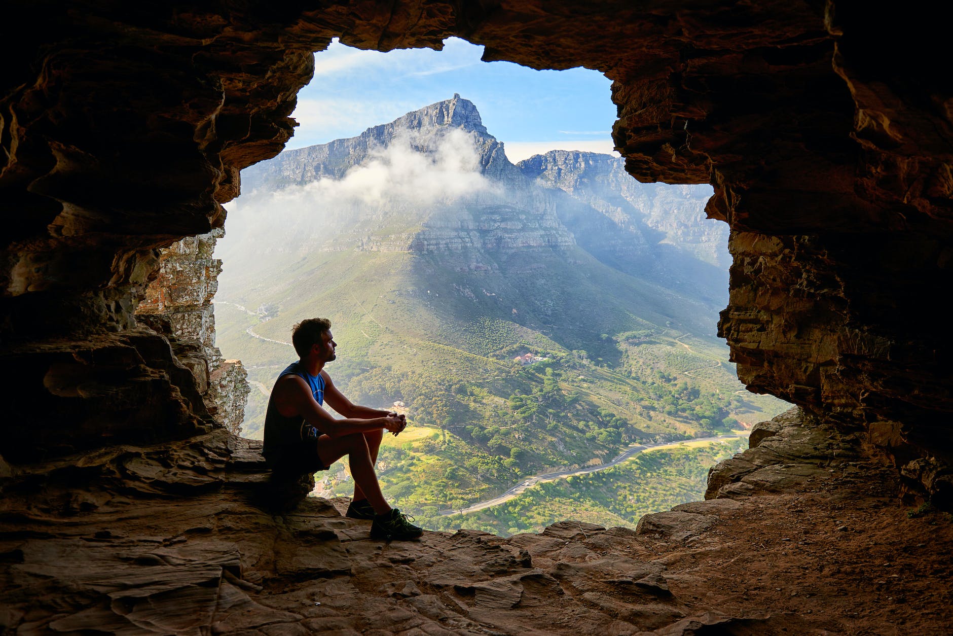 framing composition photo of man sitting on a cave