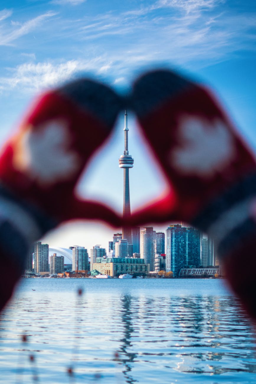 cn tower framed by hands in mittens