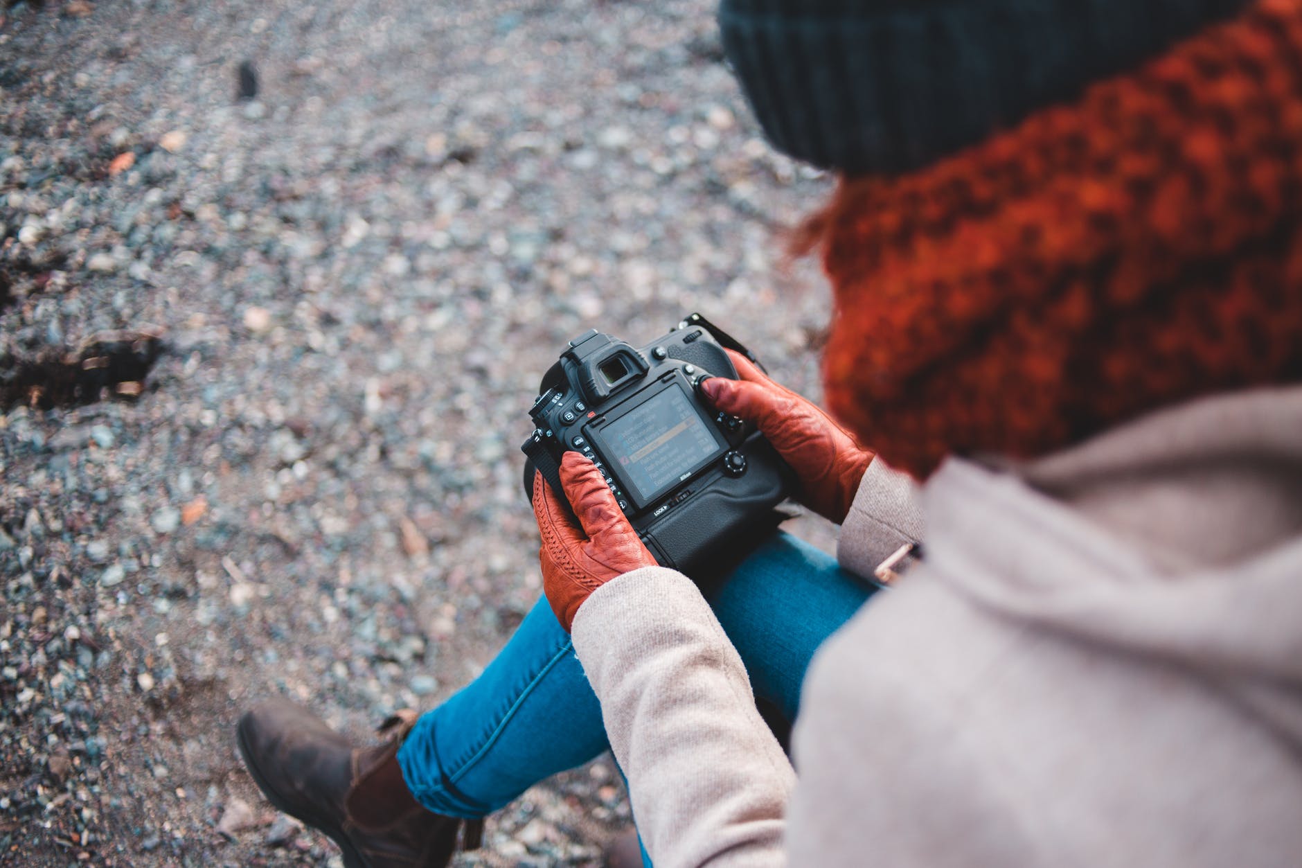 person in blue denim jeans and gloves holding a camera